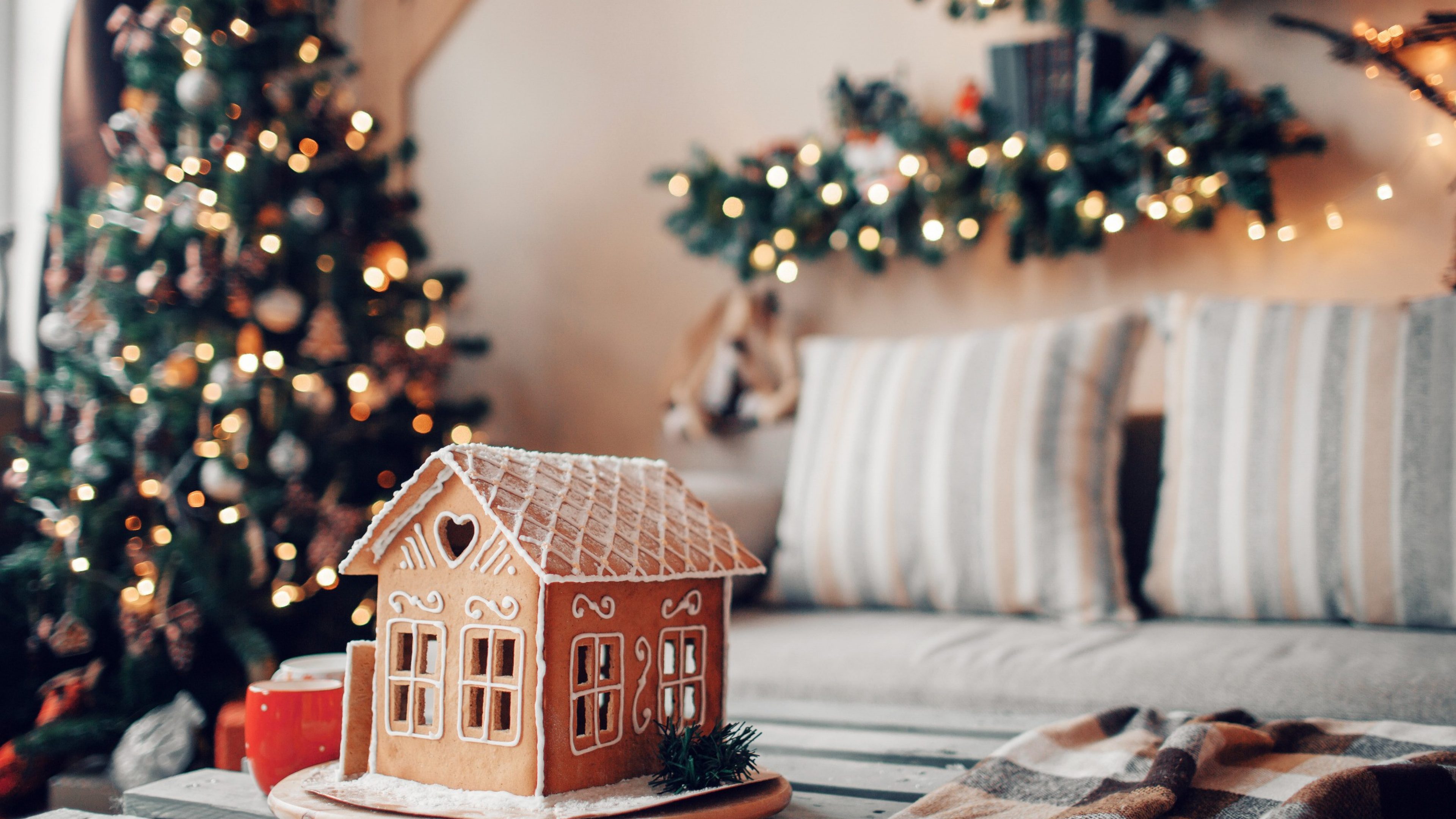 Accogliente soggiorno con albero di Natale decorato e casetta di pan di zenzero
